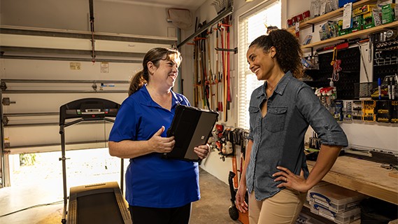 an fpl energy expert speaking with a customer in her garage explaining ways to lower her bill