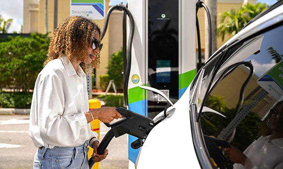 a woman charging her EV at and FPL EVolution public charger