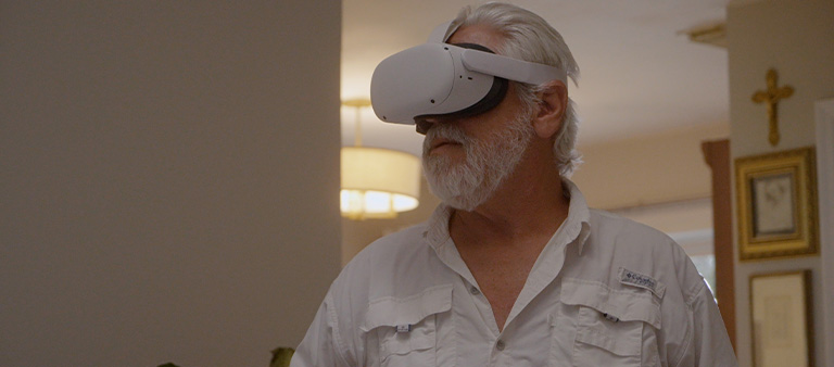 an elderly man using virtual reality goggles in his home