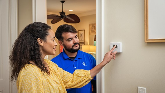 man and woman looking at thermostat